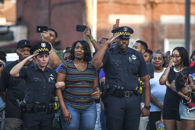 Pittsburgh police Officers Jamie Pacucci, left, and Reggie Eiland, right, both in Zone 1, comfort Angel Warren, center, the fiancee of slain Pittsburgh police Officer Calvin Hall, who died Wednesday, July 17 after being shot while off duty in Homewood, Pa., as she reacts to the call over the police scanner announcing the end of watch of Officer Hall during a ceremony in front of the Zone 1 police station, Saturday, July 20, 2019, on the North Side of Pittsburgh. (Photo by Alexandra Wimley/Pittsburgh Post-Gazette via AP Photo)