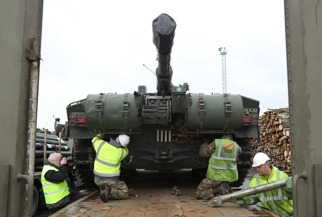 A crew secures a British Army Challenger 2 tank of the 5th Battalion The Rifles to a truck trailer after the tank and other heavy vehicles arrived by ship on March 22, 2017 at Paldiski, Estonia. British heavy tanks, light tanks, mobile artillery and other equipment unloaded at Paldiski today as part of a deployment by approximately 800 British combat troops taking part in the multinational NATO Enhanced Forward Presence battalion. NATO member states including Great Britian, France, Germany, the U.S. and Denmark are supplementing the defensive capabilities of Estonia, Latvia, Lithuania and Poland in an effort to deter Russia from attempting any military intervention in the region. (Photo by Sean Gallup/Getty Images)