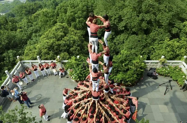 Spanish castellers form a human tower called a “castell” during a performance at the City God Pavilion, or Chenghuang Ge in Mandarin, a tourism resort near the West Lake, in Hangzhou, Zhejiang province, China, July 2, 2015. A total of 190 castellers from Spain took part in the performance on Thursday, local media reported. (Photo by Reuters/Stringer)