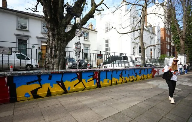A woman walks past graffiti in support of Ukraine outside the Abbey Road Studios, as Russia's invasion of Ukraine continues, in London, Britain, March 14, 2022. (Photo by Hannah McKay/Reuters)