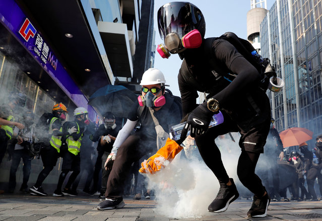 An anti-government protester holds a tear gas canister during a protest in Hong Kong, China on October 20, 2019. (Photo by Tyrone Siu/Reuters)