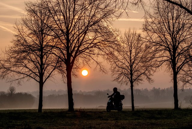 A man drives his scooter on a road on the outskirts of Frankfurt, Germany, as the sun rises on Wednesday, February 28, 2024. (Photo by Michael Probst/AP Photo)