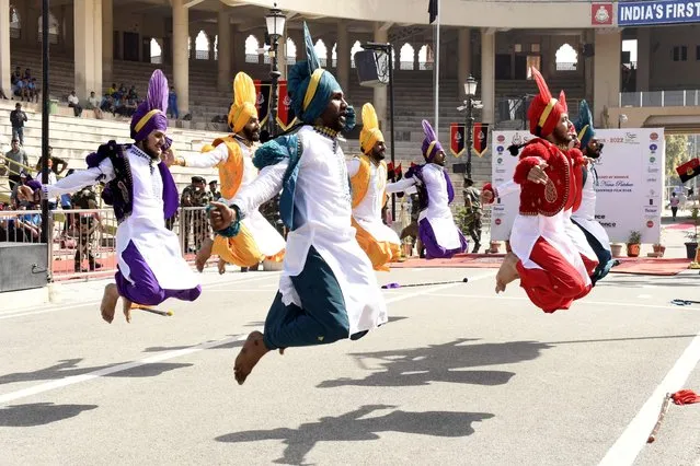 Students perform Bhangra (dance) during the closing ceremony of the “Seema Prahari Marathon” at the Indian Pakistan Wagah border post, about 35 km from Amritsar, on March 27, 2022. (Photo by Narinder Nanu/AFP Photo)