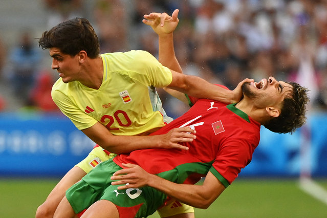 Spain's defender #20 Junlu Sanchez (L) fouls Morocco's forward #16 Abde Ezzalzouli during the men's semi-final football match between Morocco and Spain of the Paris 2024 Olympic Games at the Marseille Stadium in Marseille on August 5, 2024. (Photo by Sylvain Thomas/AFP Photo)