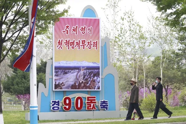 Citizens walk past a celebrative poster displayed on the occasion of 90th founding anniversary of Korean People's Revolutionary Army in Pyongyang, North Korea, Monday, April 25, 2022. Poster reads “The first Juche oriented armed force”. (Photo by Jon Chol Jin/AP Photo)