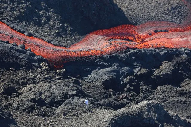 A picture taken on June 21, 2014 shows lava flowing out of the Piton de la Fournaise volcano, one of the world's most active volcanoes, located on the French island of La Reunion in the Indian Ocean. The Piton de la Fournaise started to erupt early on June 21. (Photo by Richard Bouhet/AFP Photo)
