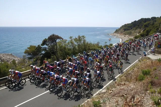 The pack rides near the coastal city of Imperia during the 13th stage of the Giro d'Italia 2022 cycling race, 150 kilometers from San Remo to Cuneo, northwestern Italy, on May 20, 2022. (Photo by Luca Bettini/AFP Photo)