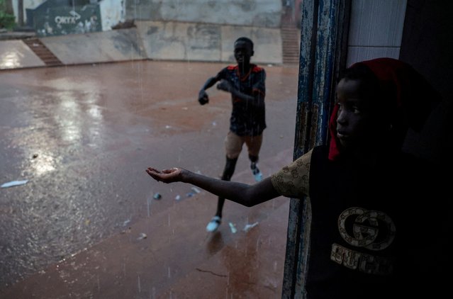 A girl looks on and a boy runs as it rains in Toubab Dialaw on the outskirts of Dakar, Senegal on September 25, 2024. (Photo by Zohra Bensemra/Reuters)