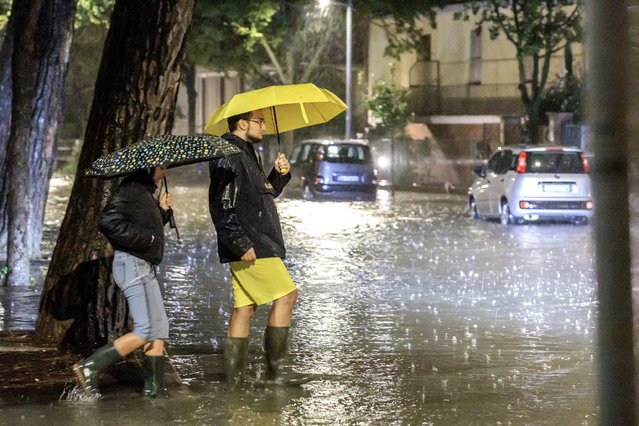 People walk in a flooded street during heavy rainfall in the city of Faenza, Emilia-Romagna region, northern Italy, 19 September 2024. Due to heavy rainfall causing rivers to overflow, more than 1,000 people have been evacuated across the Emilia-Romagna region, according to local authorities. The low-pressure system Boris brought heavy rain to central and eastern Europe starting on 11 September 2024 with five times the average monthly rainfall for September within a few days, according to the EU's Copernicus programme. Hundreds of thousands were evacuated from their homes across the region and more than twenty people died according to the latest reports from the countries affected. (Photo by Fabrizio Zani/EPA/EFE)