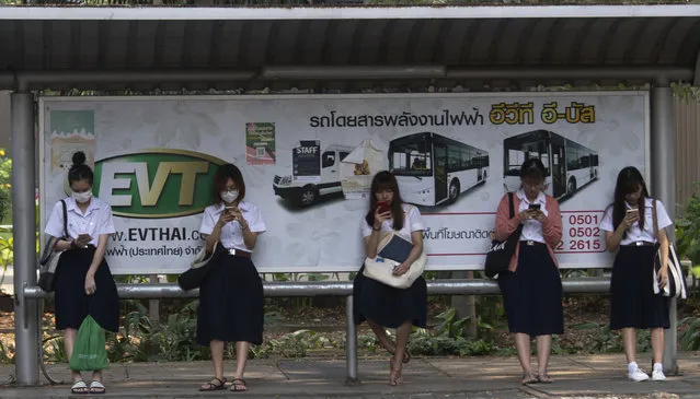 Students from Chulalongkorn University wear face masks to protect themselves from poor air quality as they wait at a bus stop in Bangkok, Thailand, Monday, January 20, 2020. (Photo by Sakchai Lalit/AP Photo)