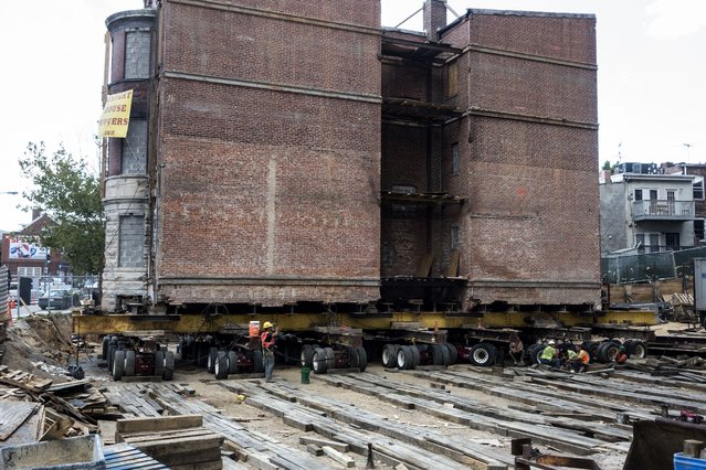 A historic building sits on wheels as it is moved down the block on New York Avenue to make way for a new construction July 28, 2014 in Washington, DC. (Photo by Brendan Smialowski/AFP Photo)