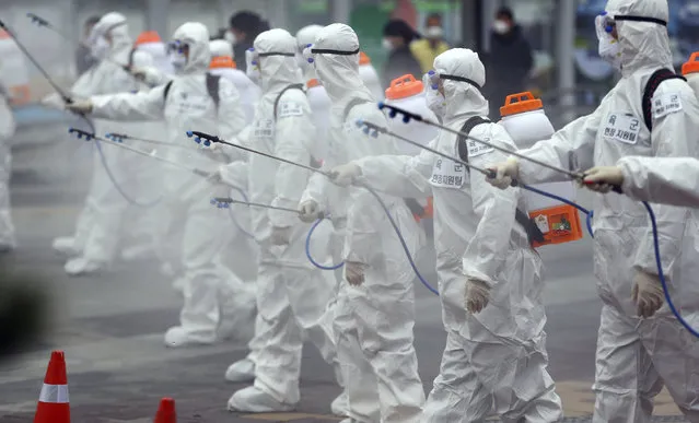 Army soldiers wearing protective suits spray disinfectant to prevent the spread of the new coronavirus at the Dongdaegu train station in Daegu, South Korea, Saturday, February 29, 2020. (Photo by Kim Hyun-tai/Yonhap via AP Photo)