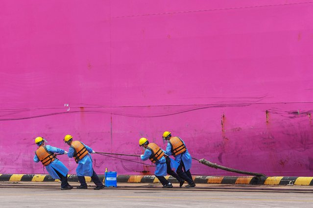 Employees work at a port in Qingdao, in China's eastern Shandong province on July 13, 2022. (Photo by AFP Photo/China Stringer Network)