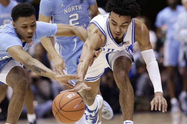 North Carolina guard Christian Keeling, left, and Duke guard Tre Jones chase the ball during the first half of an NCAA college basketball game in Durham, N.C., Saturday, March 7, 2020. (Photo by Gerry Broome/AP Photo)
