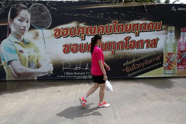 Thailand's badminton player Ratchanok Intanon (C), who hopes to win gold at the Rio Olympics, walks pass her advertisement banner at a gym in Bangkok, Thailand, June 22, 2016. (Photo by Athit Perawongmetha/Reuters)