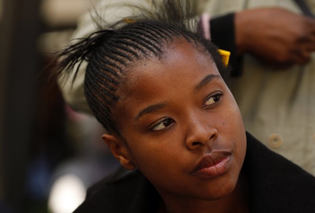 Hairdresser attends to a client in downtown Johannesburg. While the South African hair market remains divided, salons are looking to boost revenues by drawing in customers across ethnic groups, meaning hairdressers who once catered only for whites will need stylists who can also work on African hair. (Photo by Siphiwe Sibeko/Reuters)