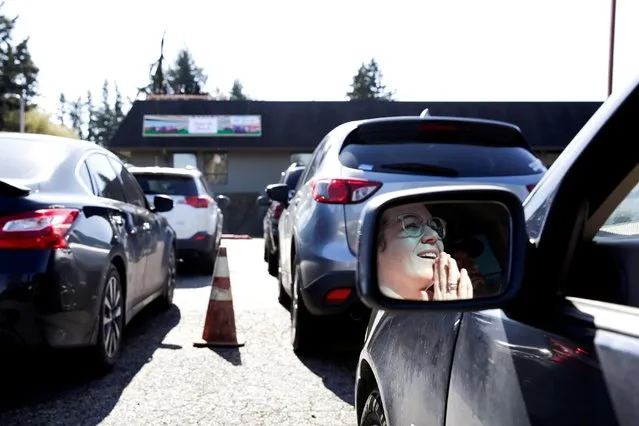 Carrie Hopkins, of Marysville, worships during a “drive-in” church service at The Grove Church where people stayed in their cars and tuned in to the pastor on their car radios after Washington Governor Jay Inslee banned large gatherings in Marysville, Washington, March 15, 2020. (Photo by Jason Redmond/Reuters)