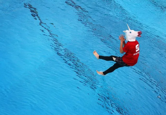 A participant of the Splashdiving World Championship wears a unicorn mask as he jumps into the Freizeitbad Silvana public swimming pool in Schweinfurt, southern Germany, on August 9, 2014. Around 50 participants try to find out until August 10, 2014 who is the “master of the cannonball”. (Photo by Karl-Josef Hildenbrand/AFP Photo/DPA)