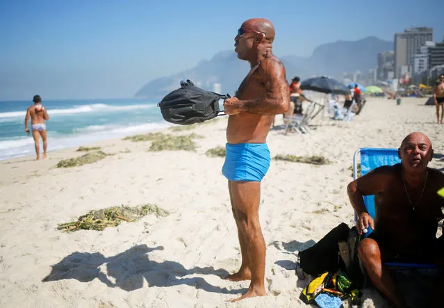A man does exercises with a bag filled with sand on Ipanema beach in Rio de Janeiro, Brazil, May 3, 2016. (Photo by Nacho Doce/Reuters)