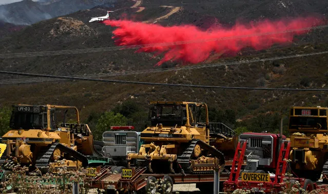 A fire fighting aircraft makes a retardant drop as fire fighters continue to battle the so-called Sand Fire in the Angeles National Forest near Los Angeles, California, United States, July 25, 2016. (Photo by Gene Blevins/Reuters)