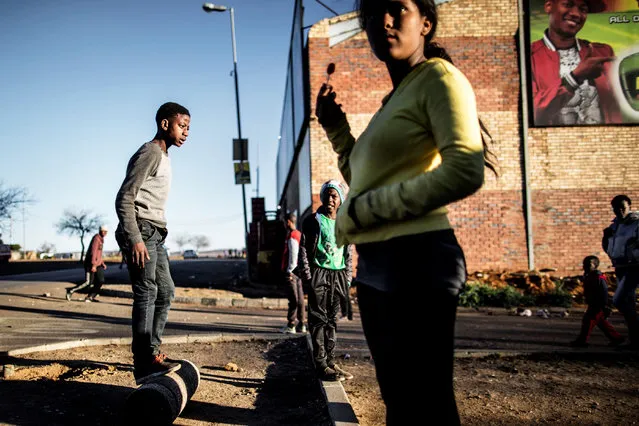 Children from the Kliptown section of Soweto are seen at play during a moment of calm of a service delivery demonstration on July 27, 2016 ahead of August 3, municipal elections. (Photo by Marco Longari//AFP Photo)