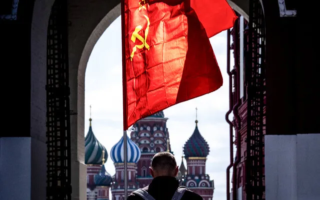 A Russian Communist party supporter carries a red flag as he walks along Red Square in Moscow on May 1, 2020. The Labour Day celebrations were cancelled due to pandemic threat of Covid-19. (Photo by Yuri Kadobnov/AFP Photo)