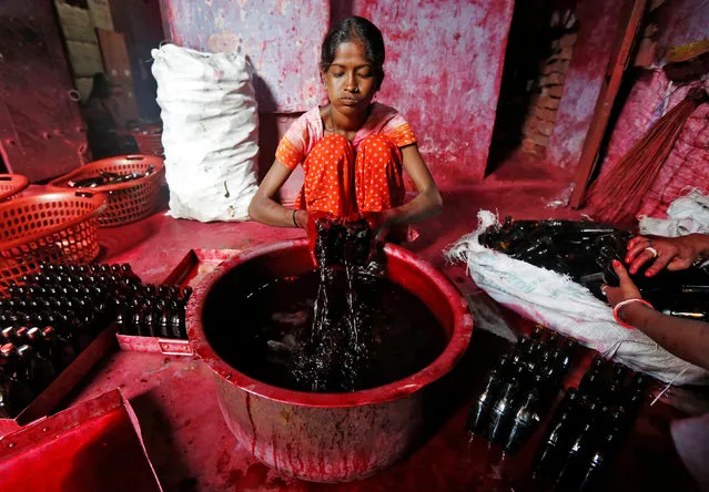 A worker fills bottles with Alta, a red dye which Hindu women apply with cotton on the border of their feet during marriages and religious festivals, at a workshop in Kolkata, India August 2, 2016. (Photo by Rupak De Chowdhuri/Reuters)