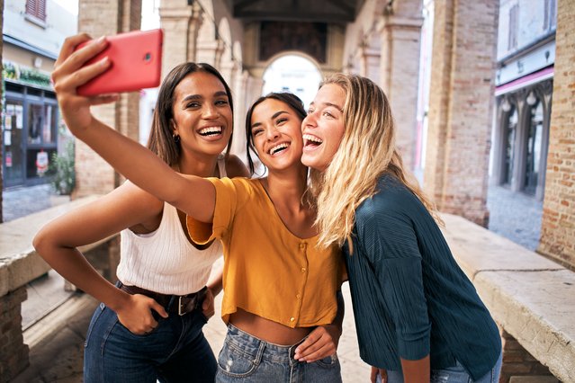 Three cheerful girls friends in summer clothes taking a selfie outdoors at the touristic urban center city. (Photo by Carlos Barquero Perez/Getty Images/iStockphoto)