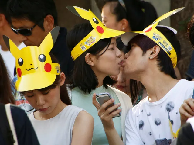 A couple kisses as they wait for start of a parade by Pokemon characters in Yokohama, Japan, August 7, 2016. (Photo by Kim Kyung-Hoon/Reuters)