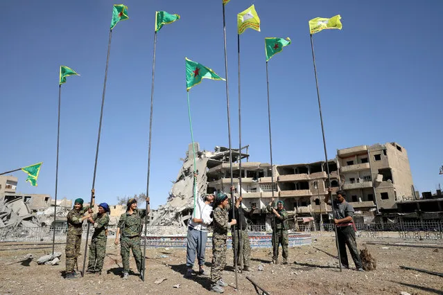 Fighters of Syrian Democratic Forces place flags at Naim Square after liberating Raqqa, Syria on October 19, 2017. (Photo by Rodi Said/Reuters)