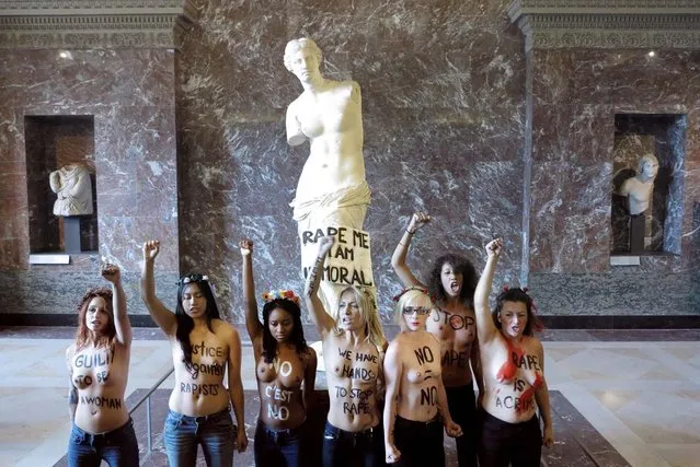Topless activists of the Ukrainian women movement Femen protest against anti women's politic in front of the Venus de Milo statue where they hung a banner, at the Louvre Museum on October 3, 2012 in Paris. AFP PHOTO LIONEL BONAVENTURE  (Photo credit should read LIONEL BONAVENTURE/AFP)