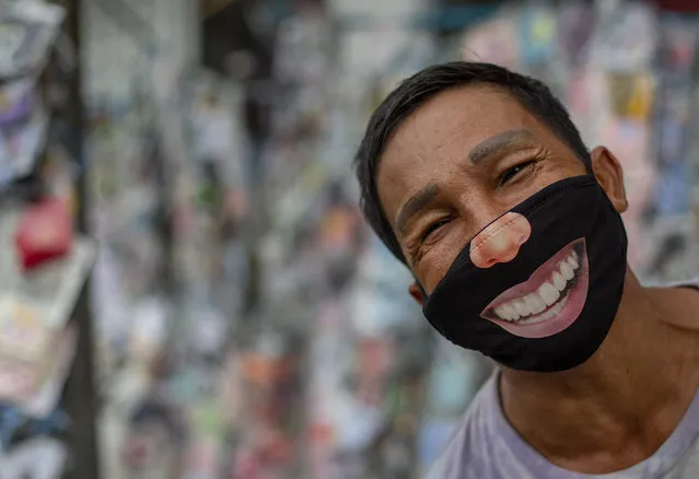 A mask seller wearing a mask stands in a street market in Bangkok, Thailand, Tuesday, June 9, 2020. Daily life in capital resuming to normal as Thai government continues to ease restrictions related to running business in capital Bangkok that were imposed weeks ago to combat the spread of COVID-19. (Photo by Gemunu Amarasinghe/AP Photo)