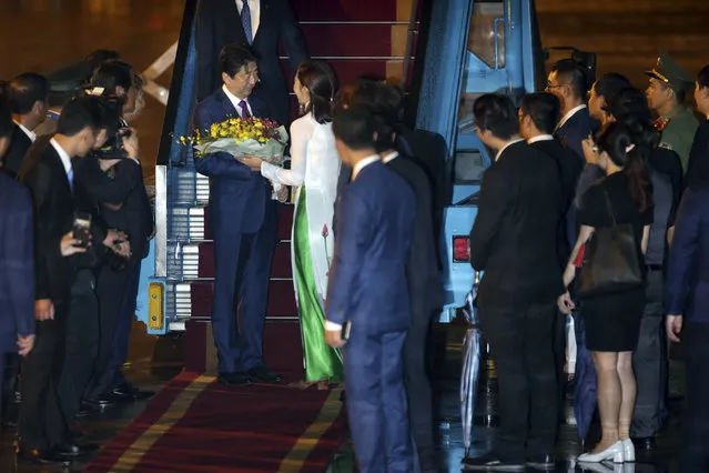 Japanese Prime Minister Shinzo Abe receives flowers as he arrives at the Da Nang International Airport in Danang, Vietnam, Thursday, November 9, 2017, to attend the Asia-Pacific Economic Cooperation (APEC) Summit. (Photo by Na Son Nguyen/AP Photo)