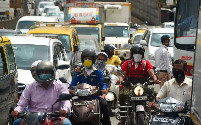 Commuters are seen in a traffic jam during rush hour as places of religious worship, hotels, restaurants and shopping malls are allowed to operate again after more than two months of lockdown imposed as a preventive measure against the COVID-19 coronavirus, in Mumbai on June 8, 2020. (Photo by Punit Paranjpe/AFP Photo)