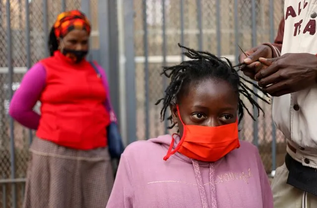 A mother looks on as her daughter is attended to by roadside hairdresser, openly flouting lockdown regulations amid the spread of the coronavirus disease (COVID-19), in Johannesburg, South Africa, June 6, 2020. (Photo by Siphiwe Sibeko/Reuters)