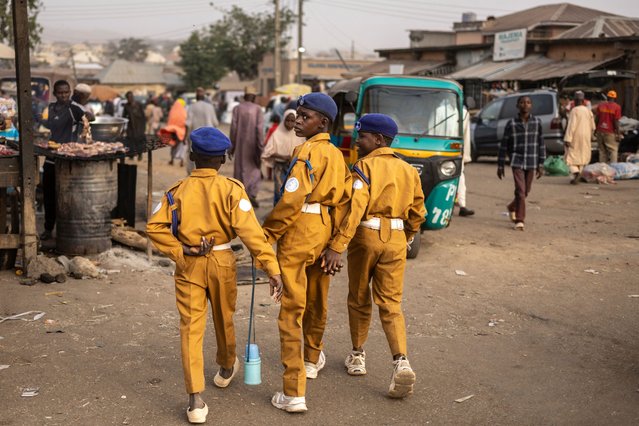 A boy looks back as he walks with other boys while wearing school uniforms in Jos, Nigeria, on February 27, 2025. (Photo by Olympia de Maismont/AFP Photo)