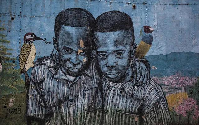 A graffiti, portraying twins with birds on their shoulders, is seen in Medellin, Colombia on November 19, 2017. (Photo by Juancho Torres/Anadolu Agency/Getty Images)