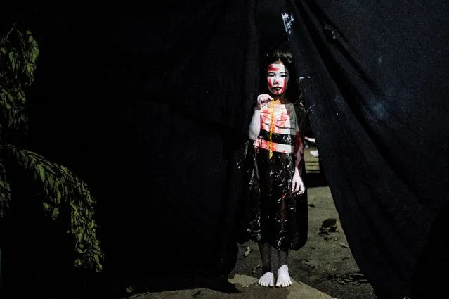 A girl dressed for Halloween poses for a photo at a horror house in Manila, Philippines on October 31, 2022. (Photo by Lisa Marie David/Reuters)