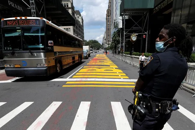 A New York City Police Department (NYPD) officer stands guard where a “Black Lives Matter” mural was vandalized with red paint along 5th Avenue outside Trump Tower in the Manhattan borough of New York City, New York, U.S., July 13, 2020. (Photo by Mike Segar/Reuters)