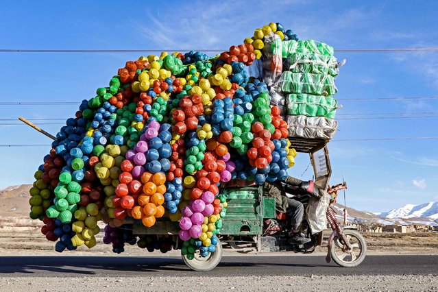 An Afghan vendor carries plastic cans on a three-wheeler rickshaw along a street on the outskirts of Maidan Wardak province on February 16, 2025. (Photo by Mohammad Faisal Naweed/AFP Photo)