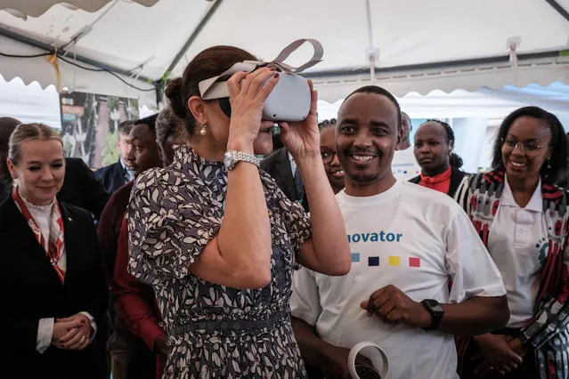 Crown Princess Victoria of Sweden (L) puts on a headset to watch virtual reality contents for schools created by Kenyan startup Cresnet at Adanian Labs, Kenya's startup hub, in Nairobi on November 22, 2022. (Photo by Yasuyoshi Chiba/AFP Photo)