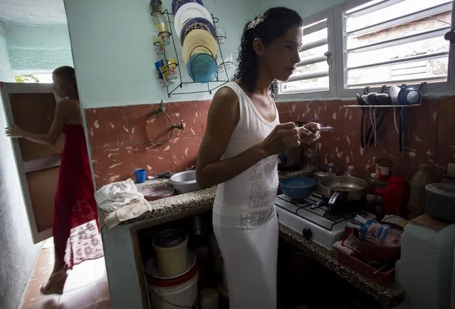 Liusba Grajales smokes in the kitchen as her fiancee Lisset Diaz Vallejo exits the bathroom, before they leave for the notary office to get married in Santa Clara, Cuba, Friday, October 21, 2022. (Photo by Ismael Francisco/AP Photo)