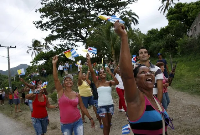 People cheer and wave flags as Pope Francis drives past in El Cobre, Cuba, September 21, 2015.. (Photo by Carlos Garcia Rawlins/Reuters)