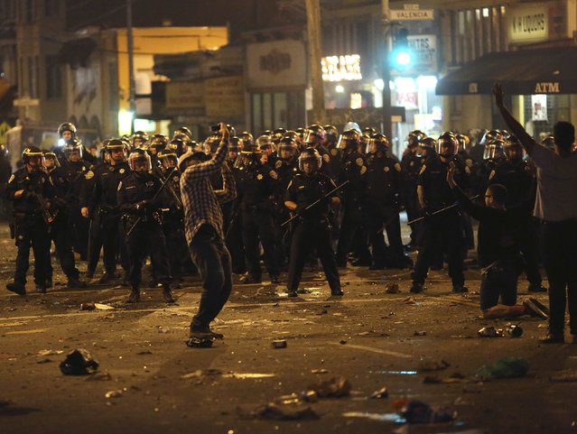 Police begin to disperse a crowd gathered in the Mission District in San Francisco, California October 29, 2014. (Photo by Robert Galbraith/Reuters)