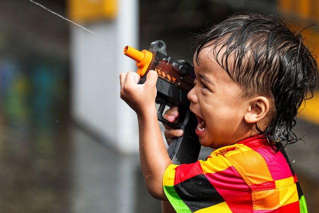 A boy plays with a water gun as he celebrates the Songkran holiday, which marks the Thai New Year, in Bangkok, Thailand, on April 12, 2025. (Photo by Chalinee Thirasupa/Reuters)