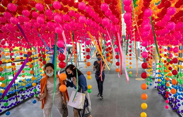 Shoppers walk through decorations at the entrance to a shopping mall promoting a sale Thursday, August 6, 2020, in Bangkok, Thailand. Thailand has managed to curb COVID-19 infections over the last three months with strict controls on entry into the country and aggressive testing and quarantine requirements. But its economy is expected to contract by at least 5% in 2020, according to the World Bank. (Photo by Gemunu Amarasinghe/AP Photo)