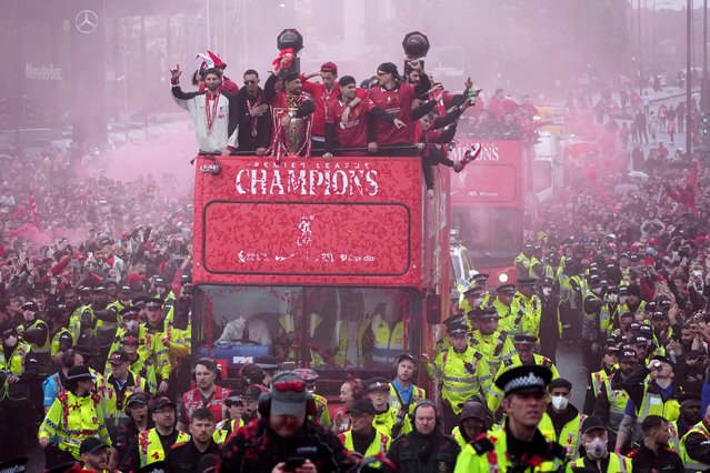 Liverpool players celebrate with the trophy on an open-top bus during the Liverpool FC Premier League victory parade in Liverpool, England, Monday, May 26, 2025. (Photo by Jon Super/AP Photo)