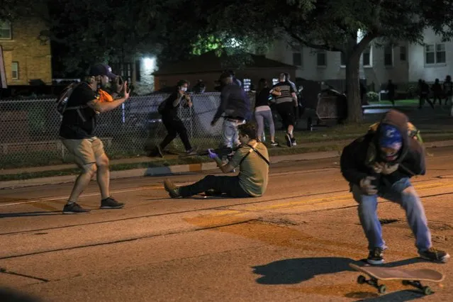 A man (R) was shot in the chest as clashes between protesters and armed civilians who protect the streets of Kenosha against the arson during the third day of protests over the shooting of a black man Jacob Blake by police officer in Wisconsin, United States on August 25, 2020. (Photo by Tayfun Coskun/Anadolu Agency via Getty Images)