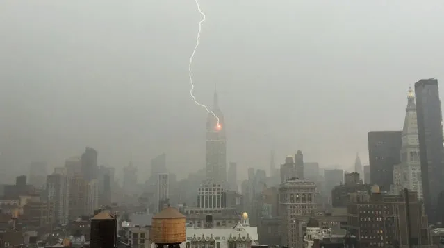 In this Monday, July 25, 2016 frame from video provided by Henrik Moltke, lightning strikes the Empire State Building during a storm in New York. Moltke said he saw the storm approaching from his office window and captured the strike by balancing his phone against the glass. (Photo by Henrik Moltke via AP Photo)