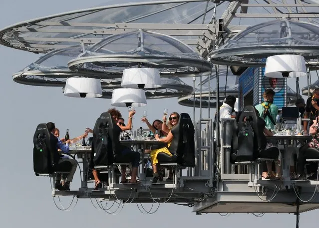 A nine tons structure that can accommodate a total of thirty two guests, suspended from a crane at a height of fifty meters is seen during an event known as “Dinner in the Sky 2.0 New Generation” in Brussels, Belgium on September 16, 2020. (Photo by Yves Herman/Reuters)